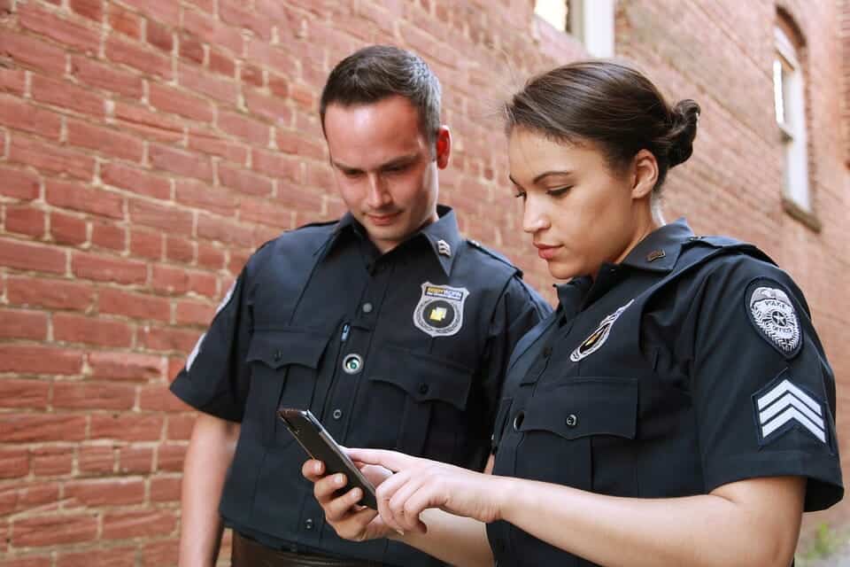 Police standing on the sidewalk observing a phone message.