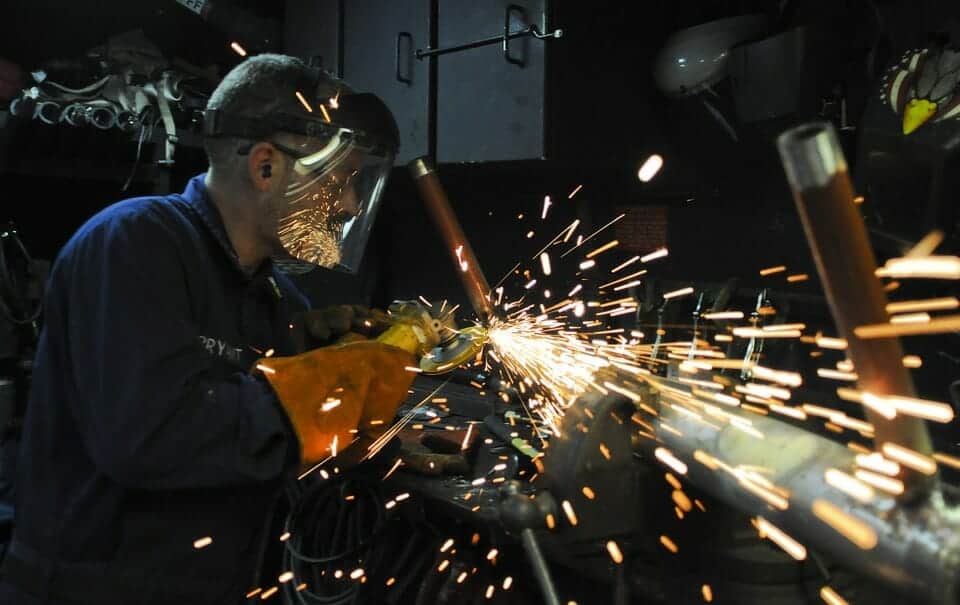 A construction worker, using a grinder to work on piping on the job site in Virginia.